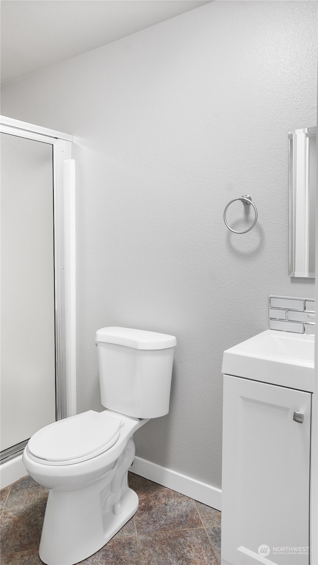 bathroom featuring a shower with shower door, vanity, tile patterned flooring, and toilet