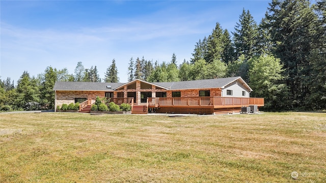 rear view of house featuring a yard and a deck