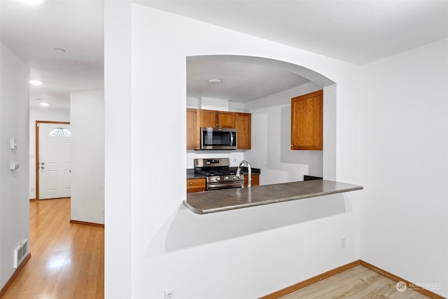 kitchen with stainless steel appliances and light hardwood / wood-style flooring