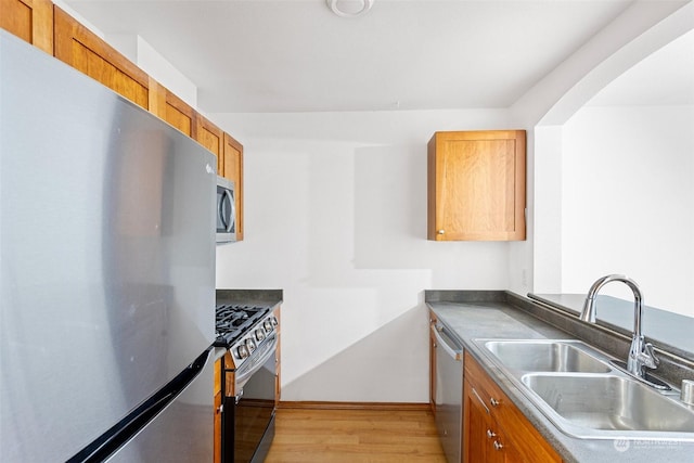 kitchen with sink, light wood-type flooring, and appliances with stainless steel finishes