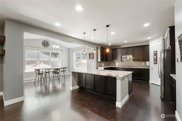 kitchen with dark hardwood / wood-style floors, decorative backsplash, kitchen peninsula, and stainless steel appliances