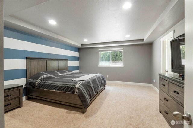 carpeted bedroom featuring a raised ceiling