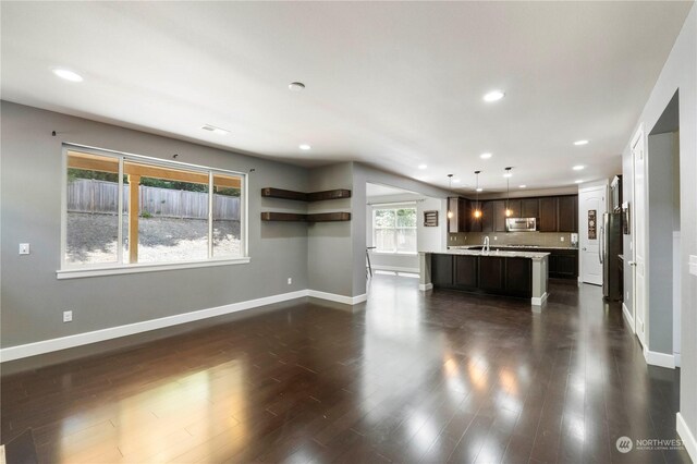 unfurnished living room with sink and dark hardwood / wood-style floors