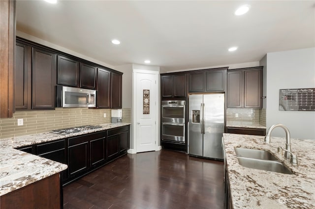 kitchen featuring dark brown cabinets, tasteful backsplash, dark hardwood / wood-style flooring, stainless steel appliances, and sink