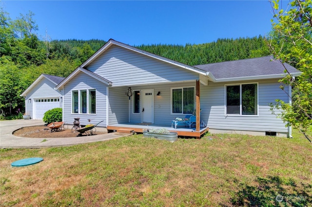 ranch-style home featuring covered porch, a front lawn, and a garage