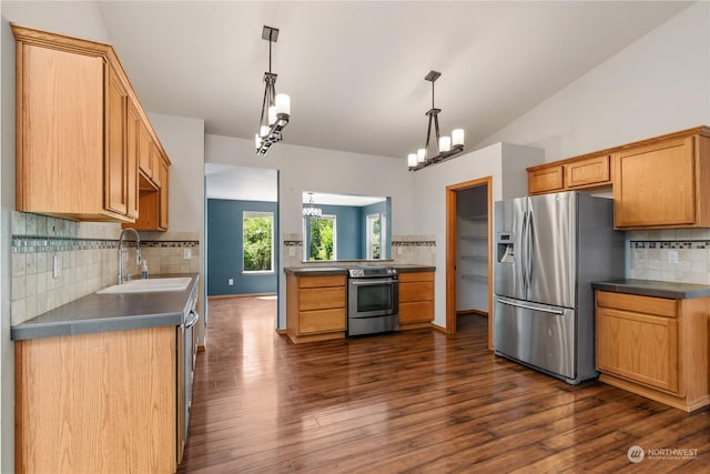 kitchen with vaulted ceiling, pendant lighting, decorative backsplash, sink, and appliances with stainless steel finishes