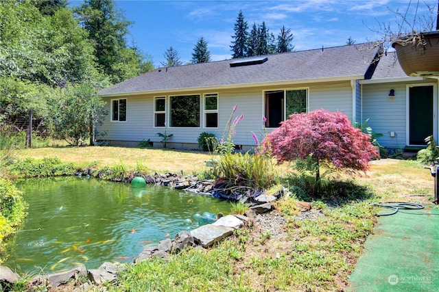 view of front of house featuring a front yard and a garden pond