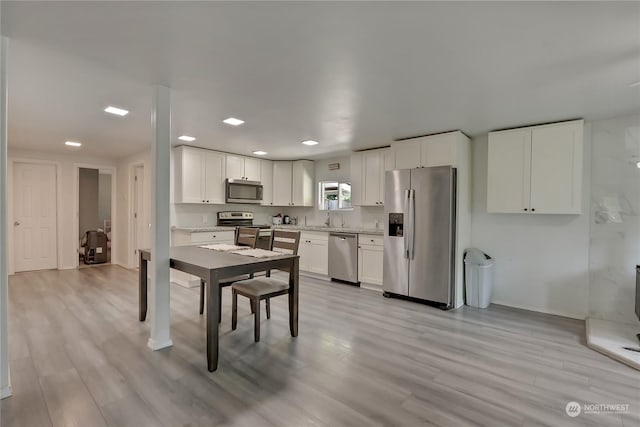 kitchen featuring white cabinetry, appliances with stainless steel finishes, sink, and light wood-type flooring