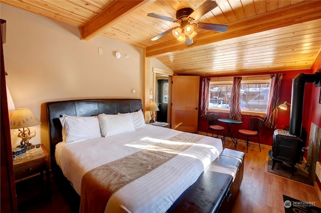 bedroom featuring a wood stove, dark hardwood / wood-style floors, lofted ceiling with beams, ceiling fan, and wooden ceiling