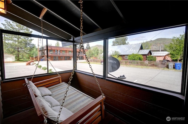 sunroom with a mountain view, lofted ceiling, and a healthy amount of sunlight