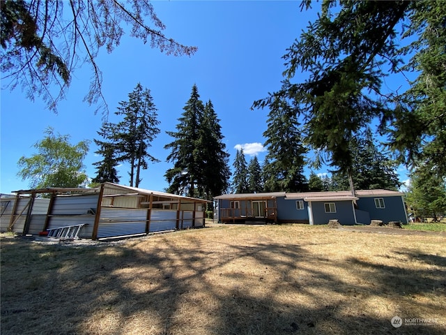 back of house featuring an outdoor structure and a lawn