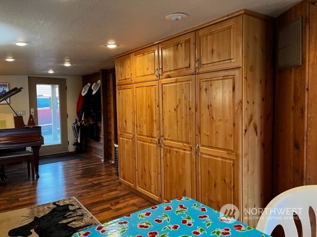 interior space featuring a textured ceiling and dark hardwood / wood-style floors