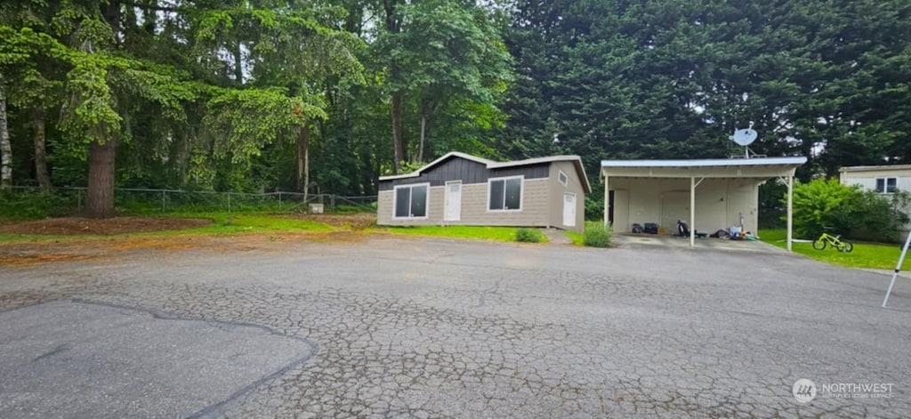 view of front of property featuring driveway and fence