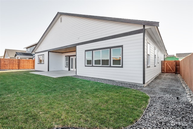 rear view of house featuring a lawn and a patio area