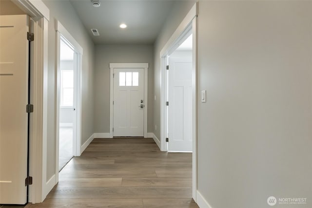 doorway with light wood-style flooring, visible vents, baseboards, and recessed lighting