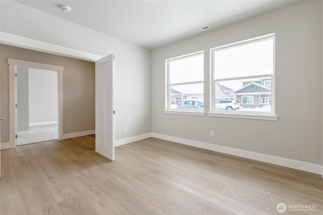 interior space with baseboards, visible vents, and light wood-style floors