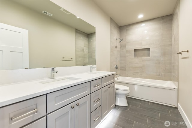 full bathroom with toilet, washtub / shower combination, visible vents, and a sink