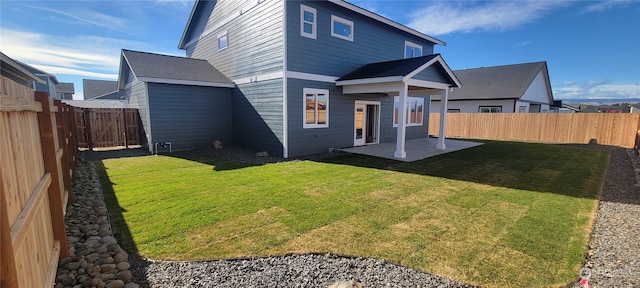 back of house featuring a lawn and a patio area