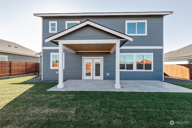 rear view of property with a lawn and a patio