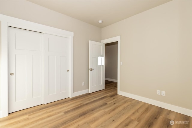 unfurnished bedroom with light hardwood / wood-style flooring and a closet