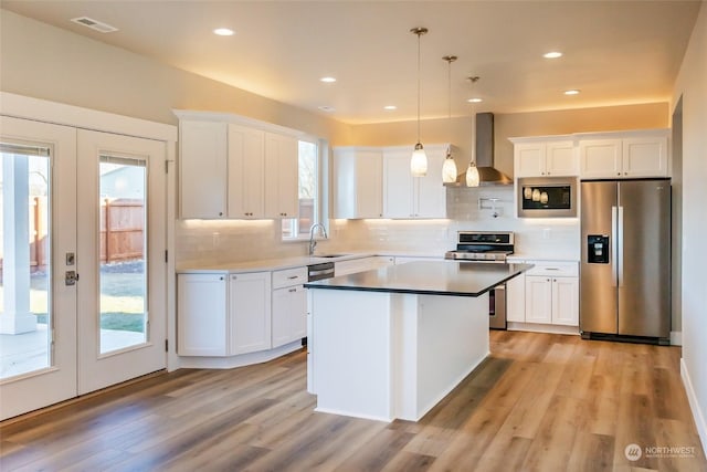 kitchen with pendant lighting, stainless steel appliances, and white cabinetry