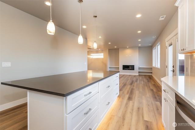 kitchen with decorative light fixtures, light hardwood / wood-style flooring, dishwasher, a center island, and white cabinetry