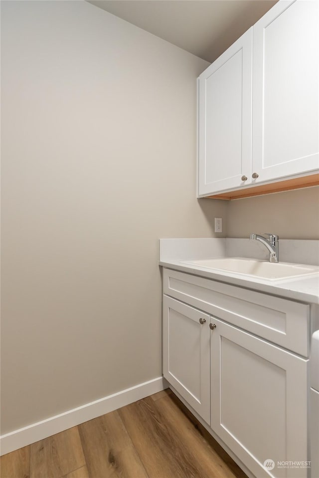 laundry area with light wood-type flooring and sink