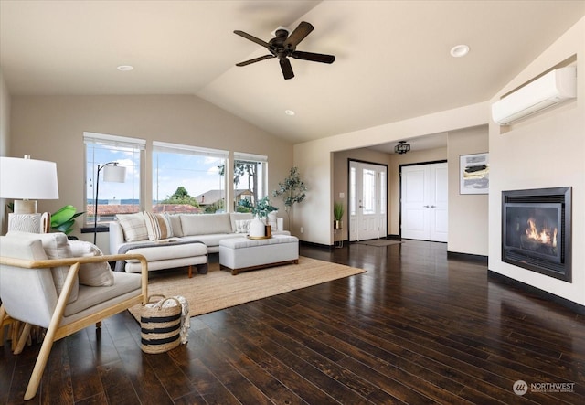 living room with dark wood-style flooring, a wall unit AC, a glass covered fireplace, vaulted ceiling, and baseboards