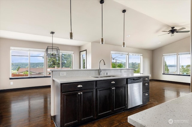 kitchen with vaulted ceiling, sink, hanging light fixtures, stainless steel dishwasher, and a center island with sink