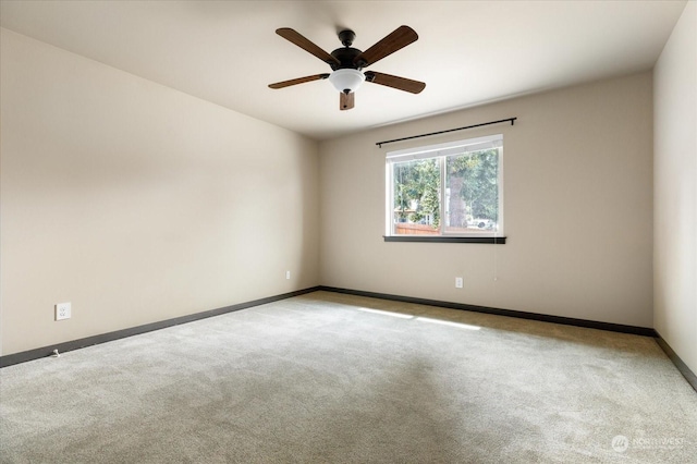 empty room featuring baseboards, ceiling fan, and light colored carpet