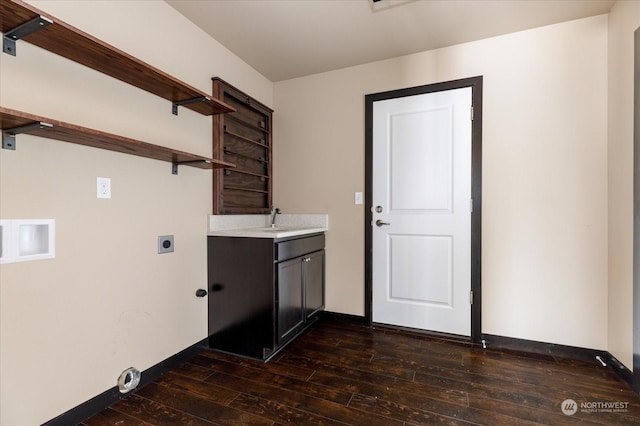 washroom with cabinet space, baseboards, dark wood finished floors, hookup for an electric dryer, and a sink