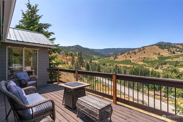 deck with a mountain view and a fire pit