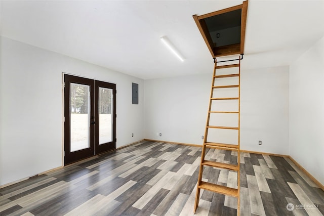 empty room with dark hardwood / wood-style flooring, electric panel, and french doors