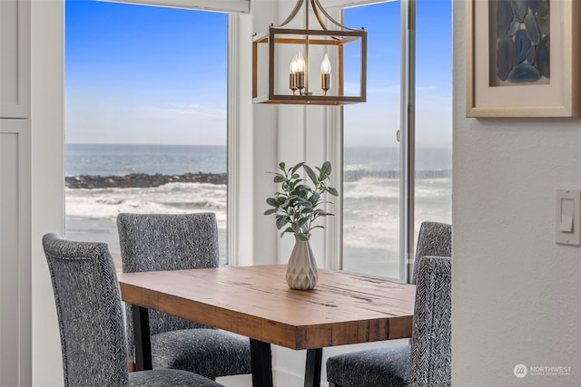 dining space with a water view, a wealth of natural light, and an inviting chandelier