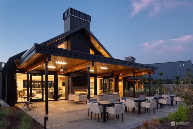 rear view of house with a patio area and a fireplace