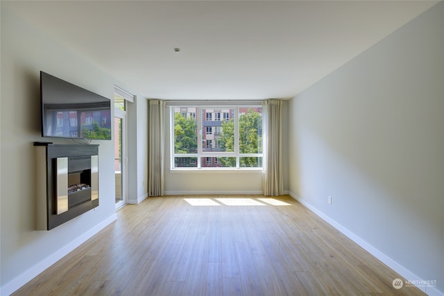 unfurnished living room featuring a fireplace and light hardwood / wood-style floors