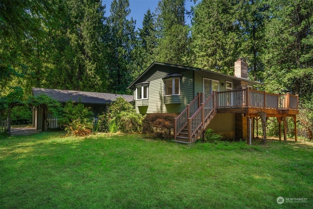 rear view of property featuring a yard and a deck