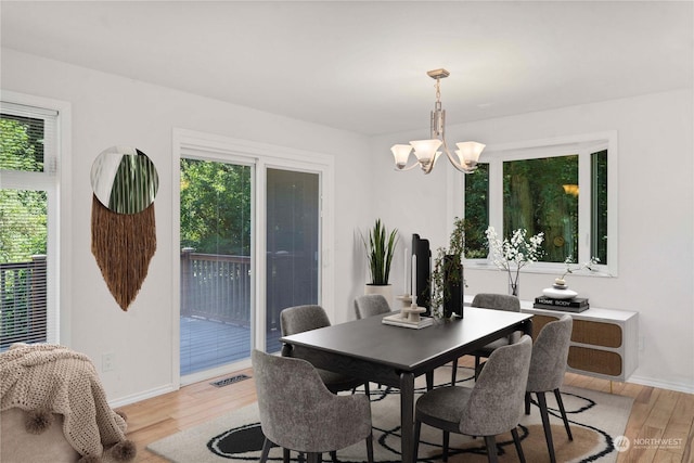 dining space featuring a notable chandelier and light hardwood / wood-style flooring