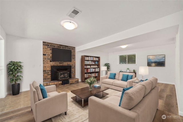 living room with a wood stove and light hardwood / wood-style flooring