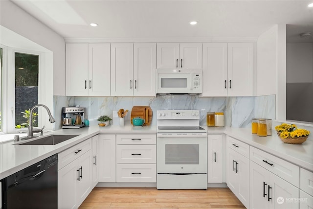 kitchen featuring tasteful backsplash, sink, white cabinets, white appliances, and light hardwood / wood-style flooring