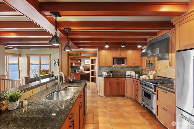 kitchen featuring beamed ceiling, exhaust hood, pendant lighting, appliances with stainless steel finishes, and a water view