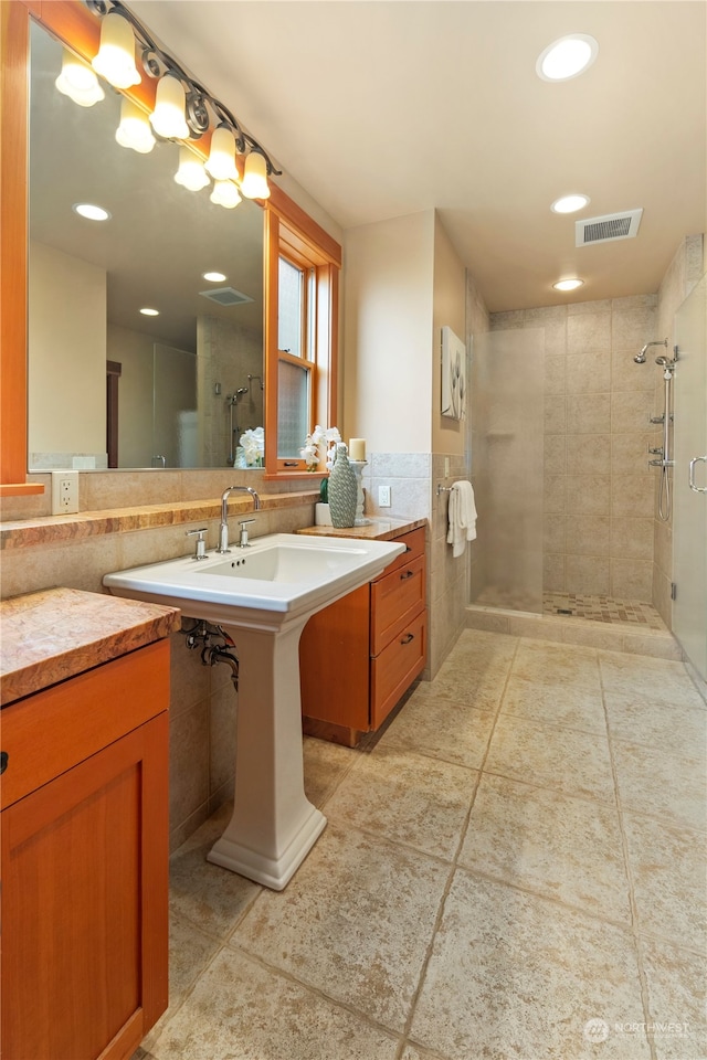 bathroom featuring vanity, tile walls, and a shower with shower door