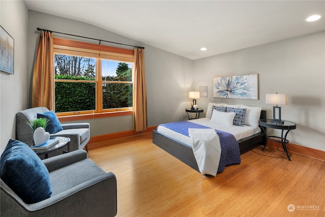 bedroom featuring vaulted ceiling and light hardwood / wood-style floors