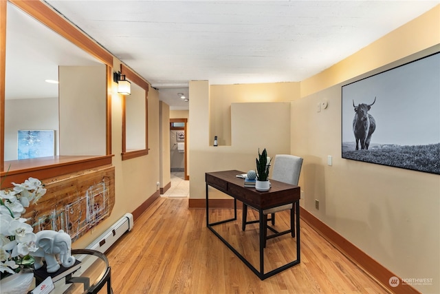 office area with light hardwood / wood-style flooring and a baseboard heating unit