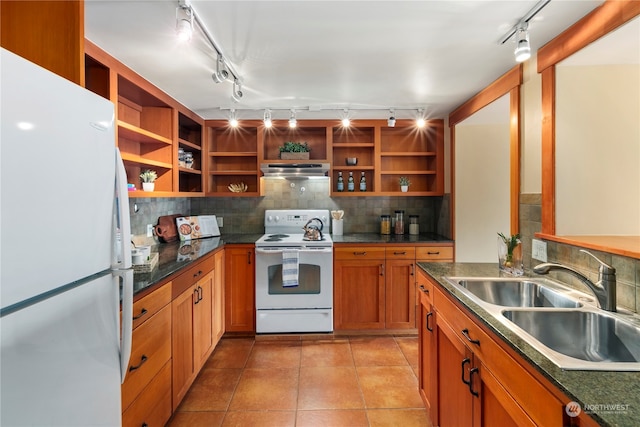 kitchen featuring decorative backsplash, rail lighting, light tile patterned floors, sink, and white appliances