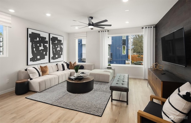 living room featuring light hardwood / wood-style floors and ceiling fan