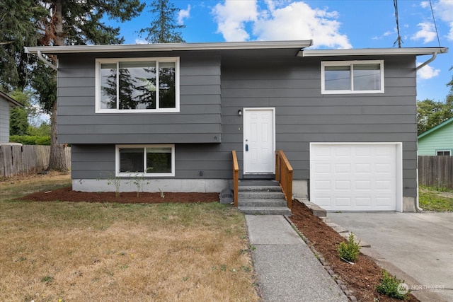 split foyer home featuring a garage and a front lawn