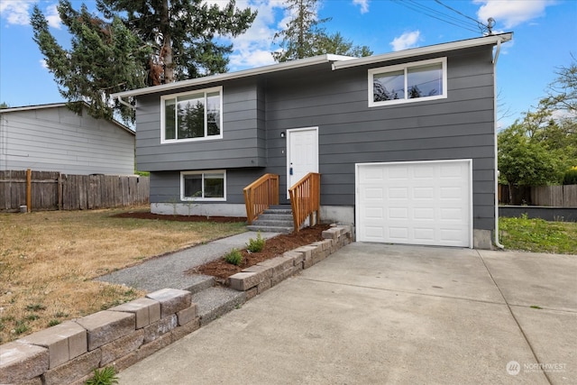 raised ranch with a front lawn and a garage