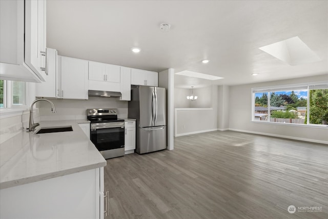 kitchen featuring a healthy amount of sunlight, stainless steel appliances, sink, and a skylight