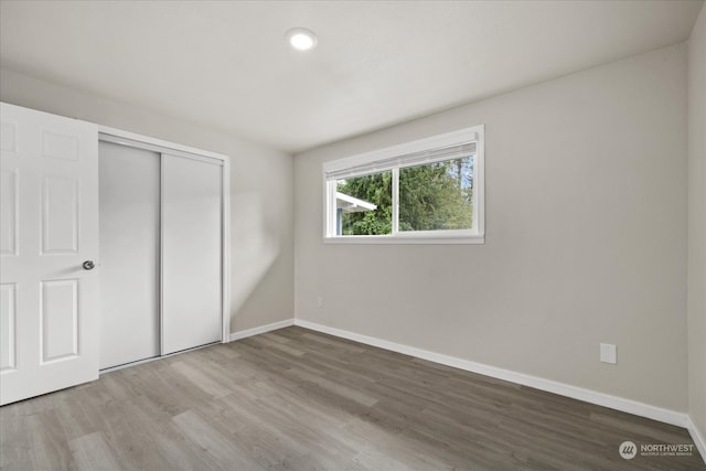 unfurnished bedroom with a closet and wood-type flooring